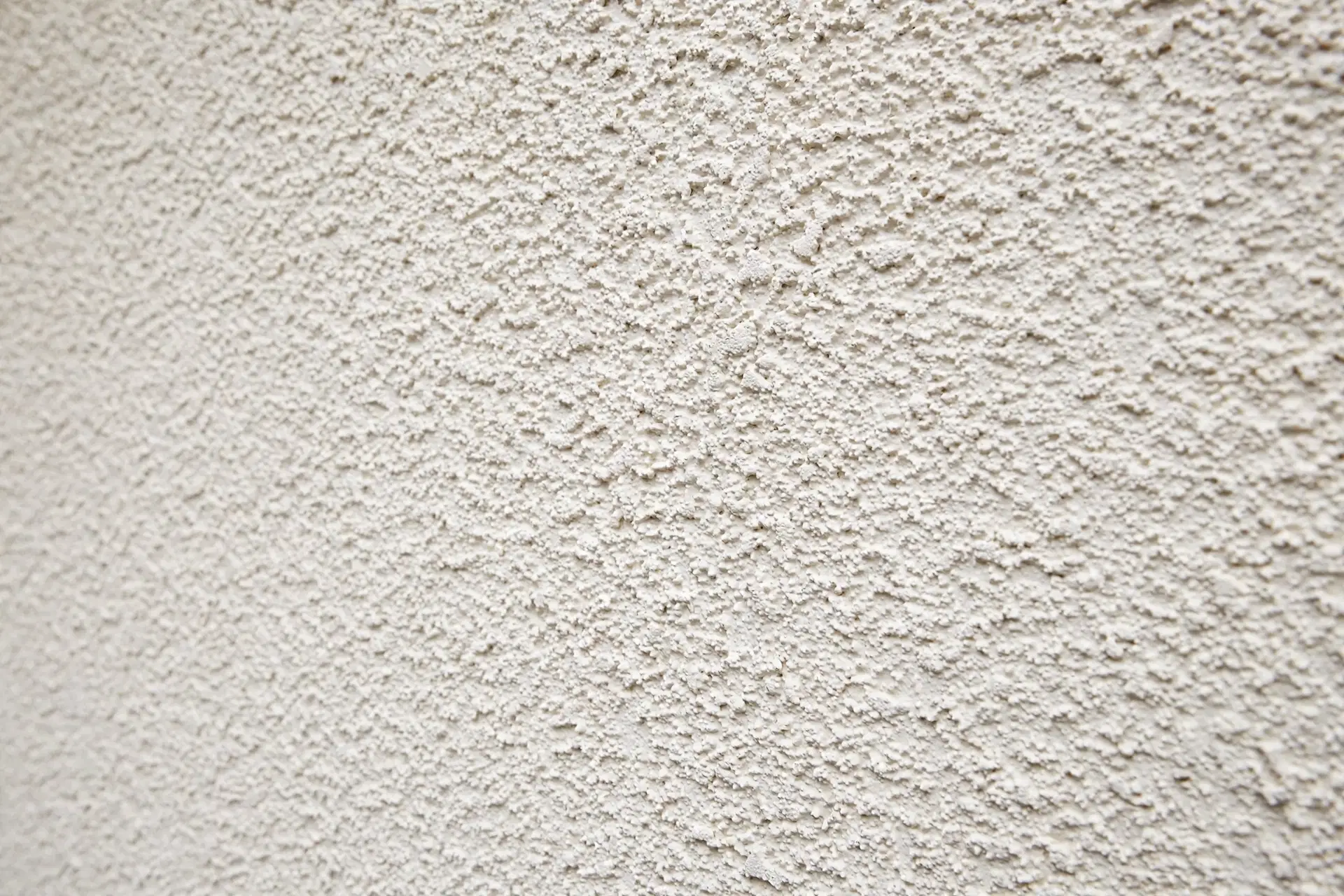 House Painters in Waitangirua: Best Local Painting Contractors 4 Close-up of a freshly coated textured stucco exterior wall in warm white with an even, clean finish